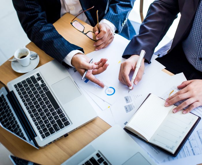 Business,Team,Hands,At,Working,With,Plan,On,Office,Desk